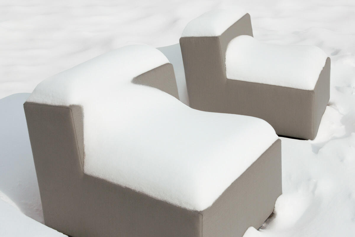 Weatherproof garden furniture covered in snow