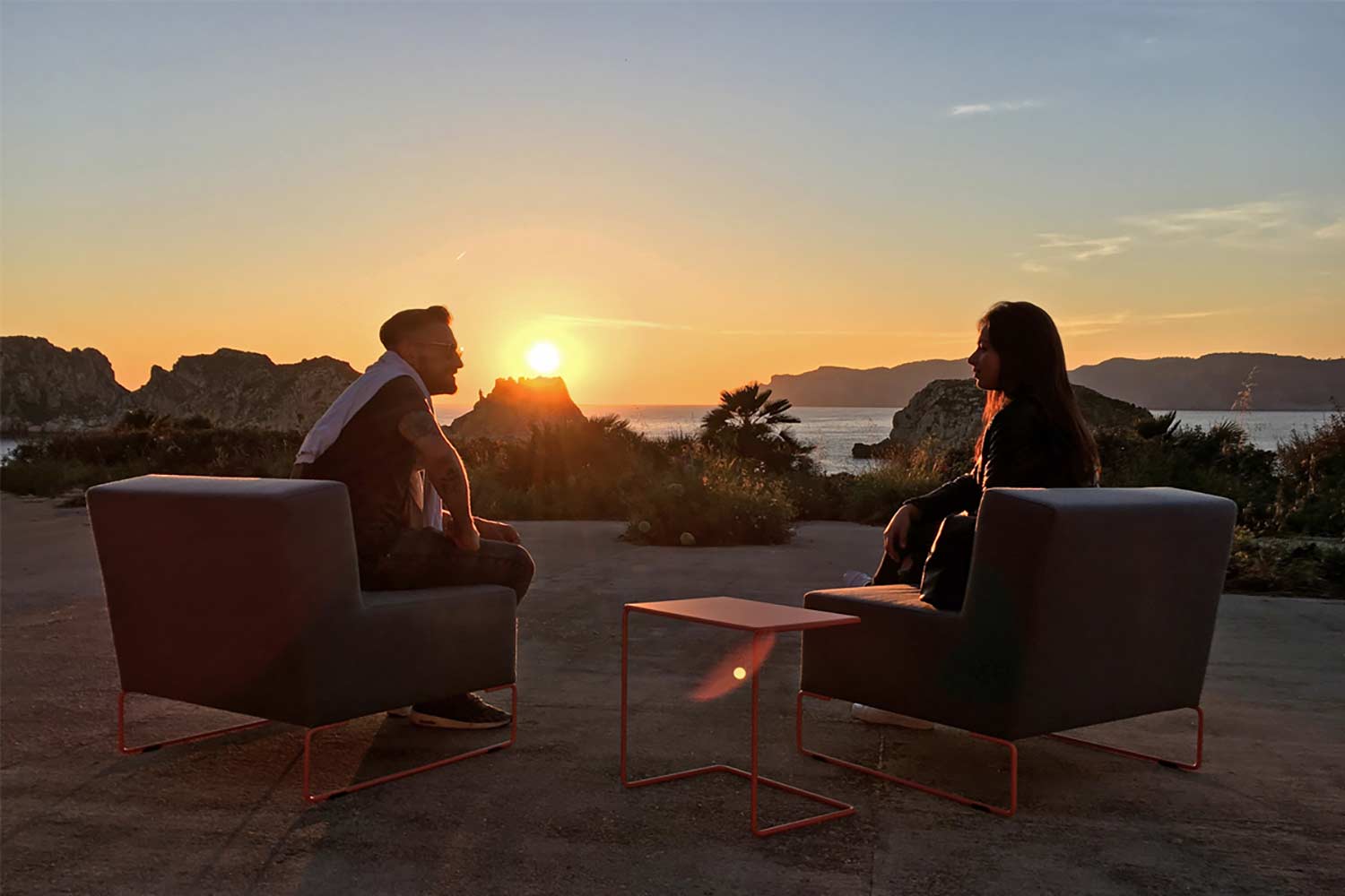 Zwei Personen sitzen auf Gartenloungesesseln im Garten am Meer
