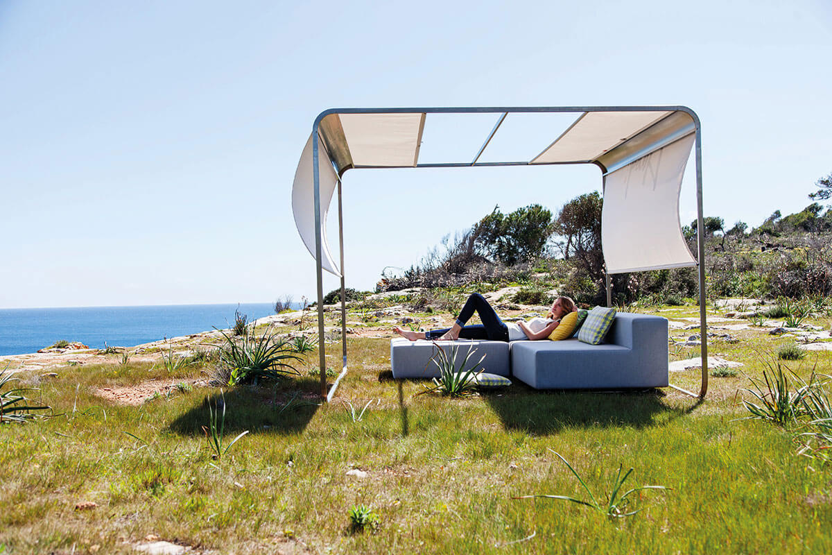 Roll-up design sun sail as wind and sun protection for an outdoor lounge set
